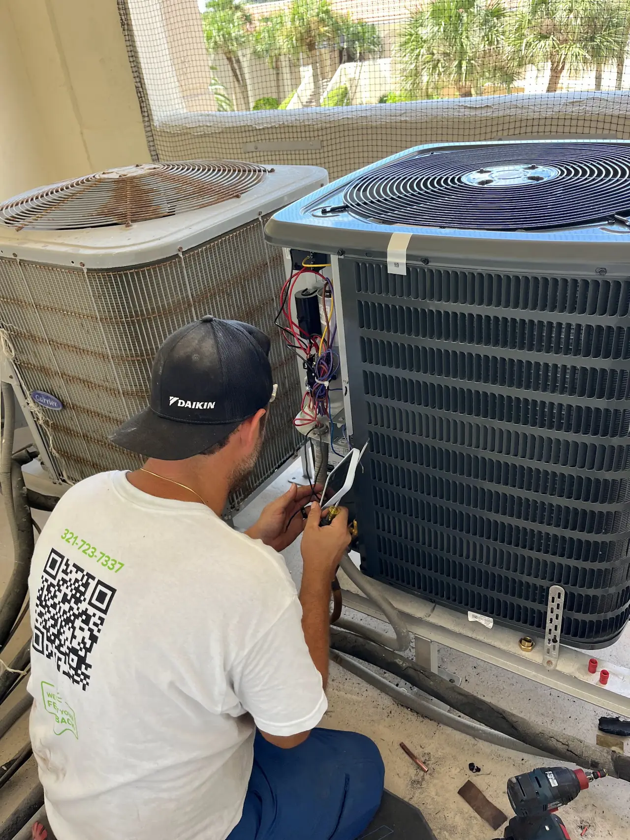Technician in a Daikin cap working on a residential condenser