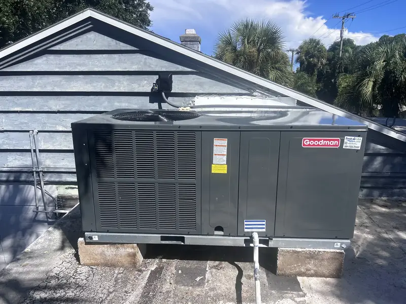 Goodman rooftop unit beside a pitched roof