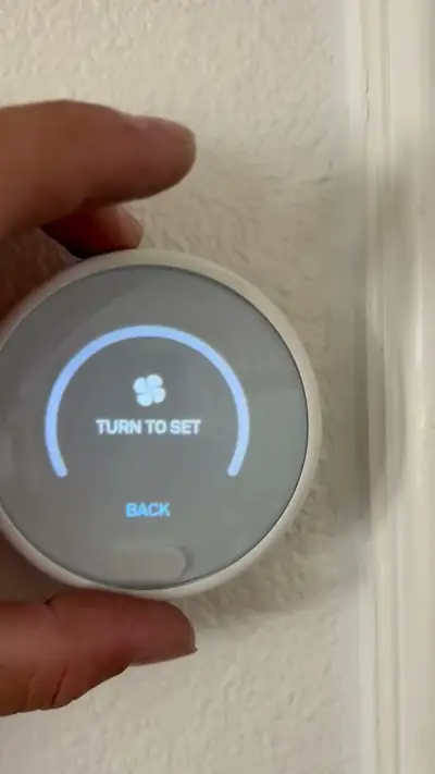 Homeowner adjusting a smart thermostat